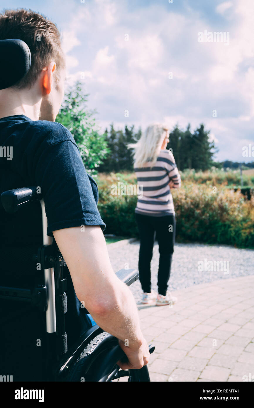 Mann mit dystonie im Rollstuhl und Frau in Beziehung Kampf Stockfoto