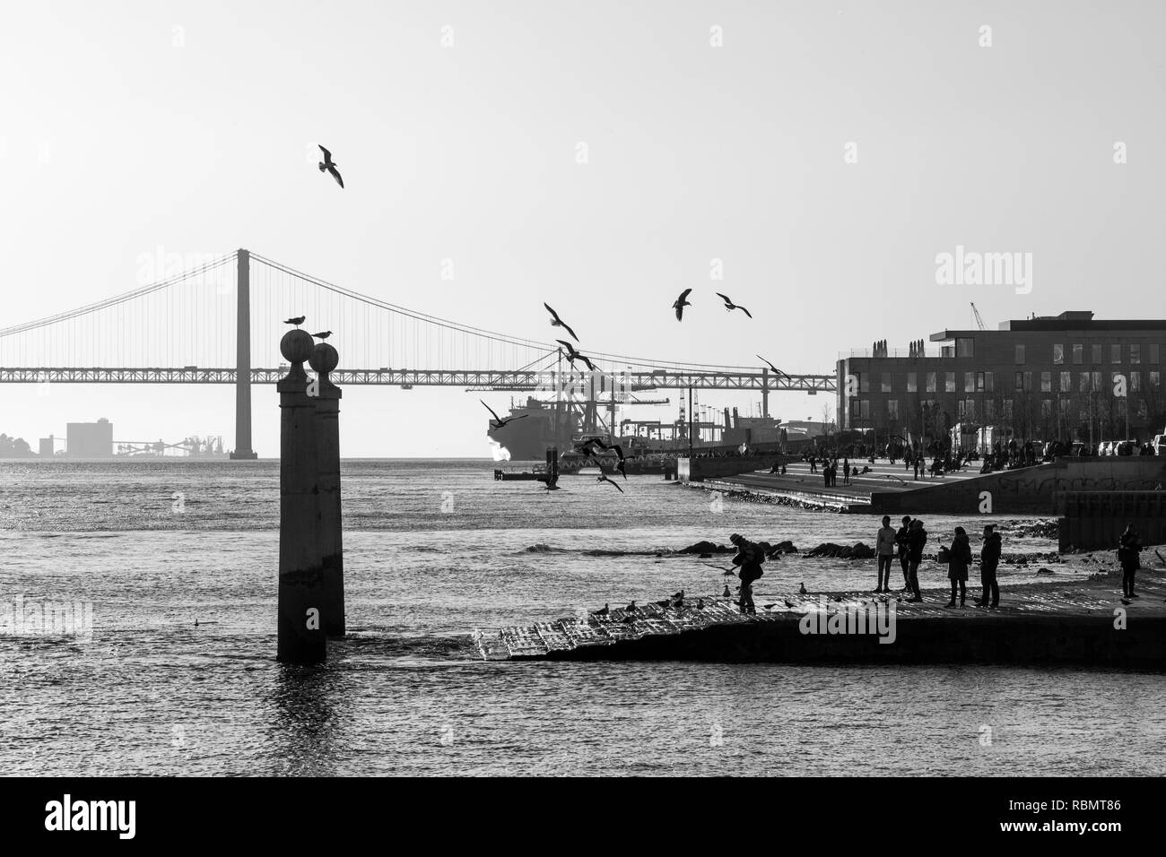 Schwarz-weiß Foto von Cais das Colunas (in der Nähe der Handels Platz) und der 25. April Brücke, Lissabon, Portugal. Stockfoto