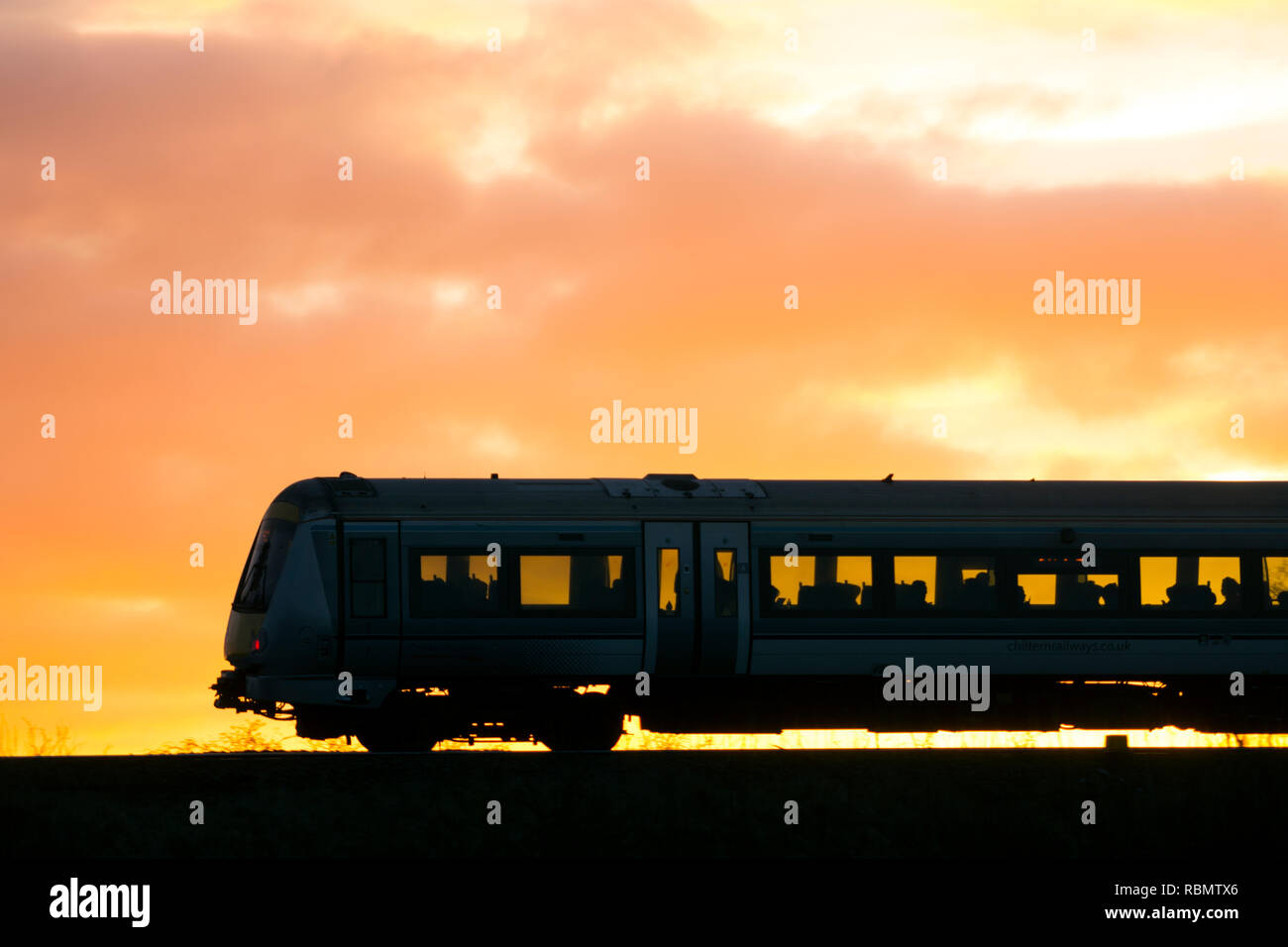 Chiltern Railways diesel Zug bei Sonnenuntergang Silhouette, Warwickshire, Großbritannien Stockfoto