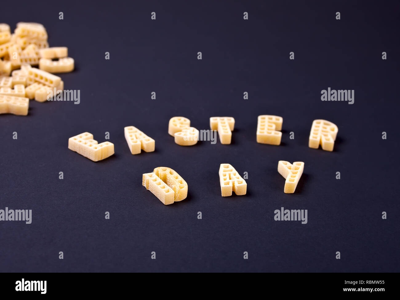 Text Ostern Tag mit Makkaroni in Form von Buchstaben auf schwarzem Holz- Tabelle geschrieben Stockfoto