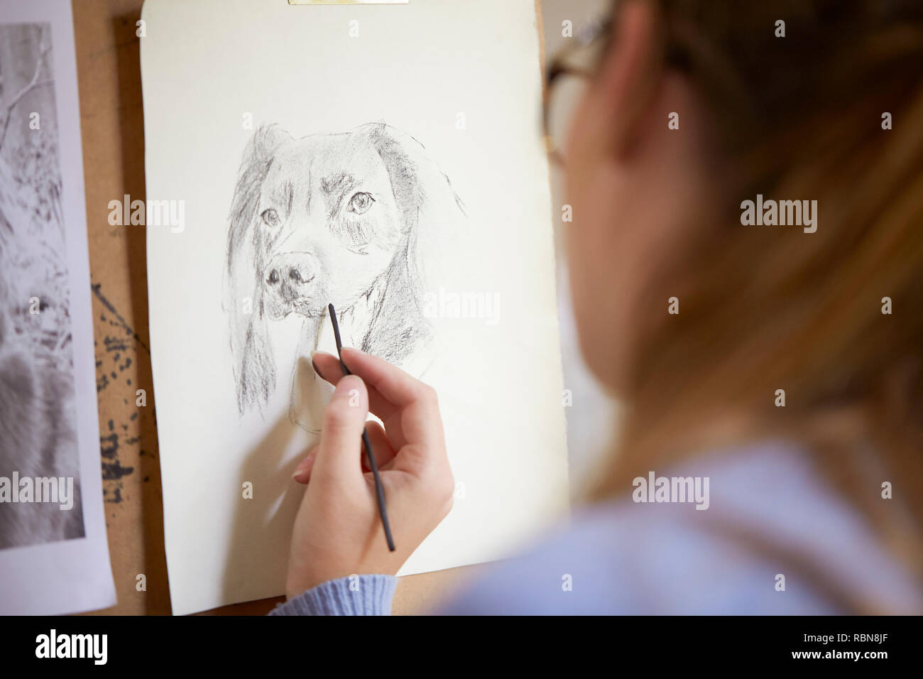 In der Nähe der weiblichen Teenager Künstler sitzen an Staffelei Zeichnung Bild von Hund von Foto in Anthrazit Stockfoto