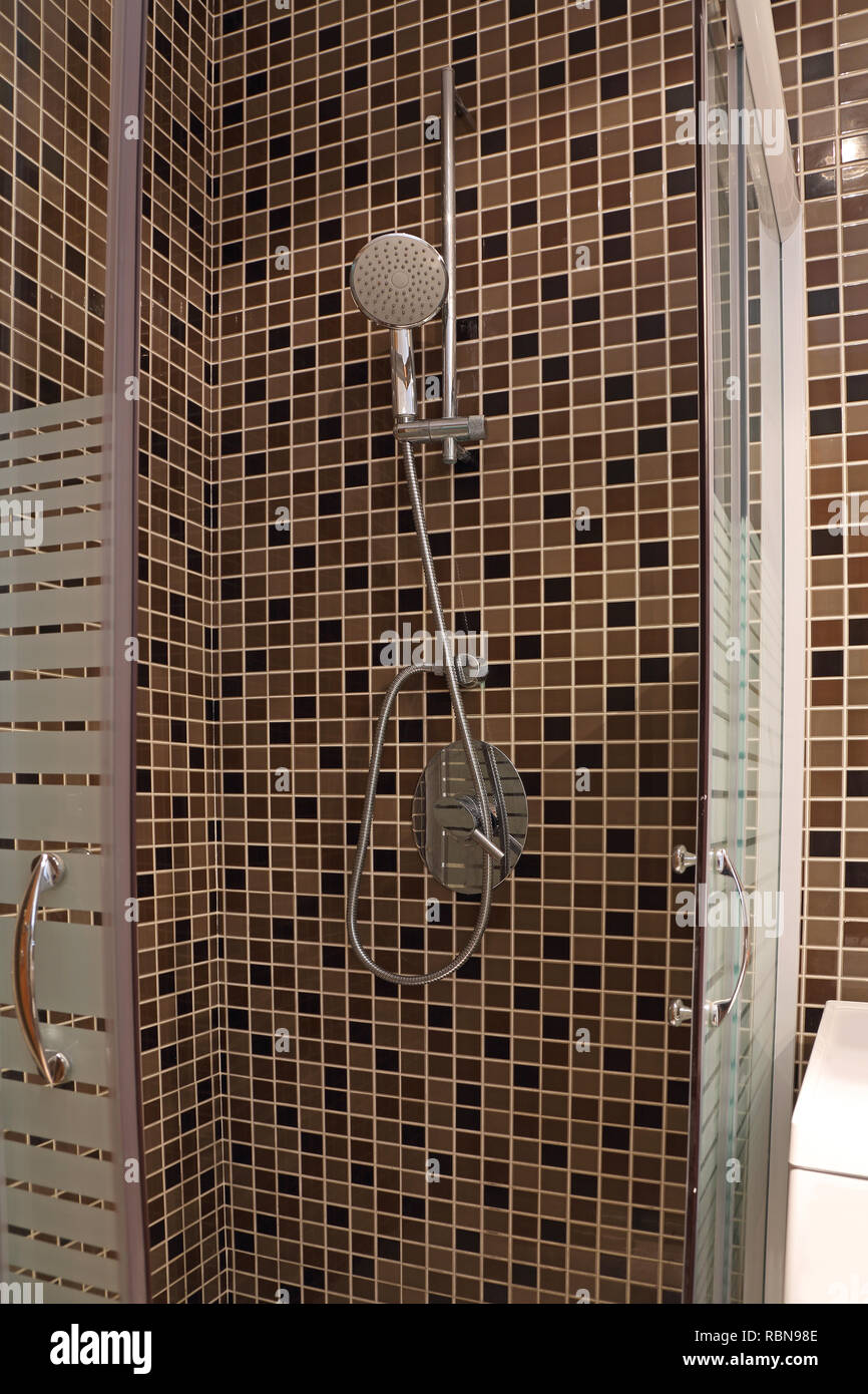 Moderne Dusche mit braunen Fliesen Mosaik und Glas Kabinentür  Stockfotografie - Alamy