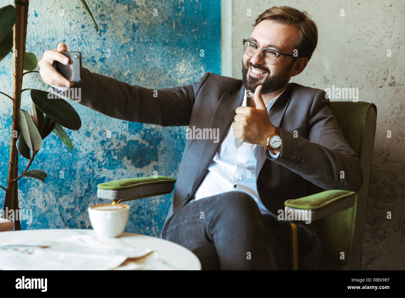 Lächeln, Geschäftsmann, tragen, Klage, eine selfie während im Cafe sitzen und Kaffee trinken Stockfoto