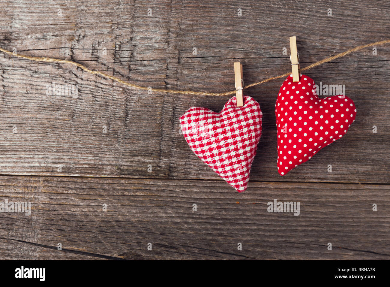 Schönen Valentines Tag textile Herz hängt am Seil auf alten hölzernen Hintergrund. Blick von oben. Valentines Tag Konzept. Stockfoto