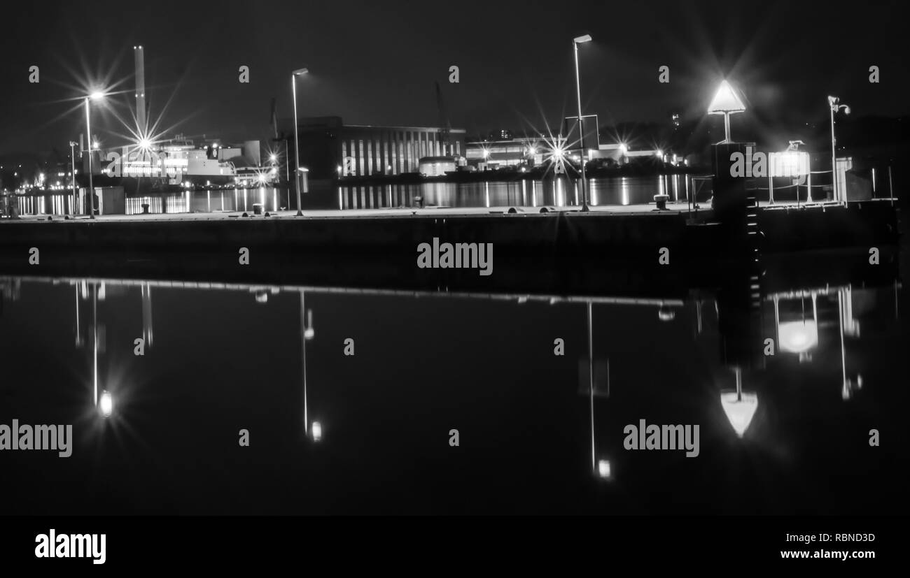 Schwarze und weiße Nacht Szene einer Pier vor der Docks in Flensburg, Deutschland. Stockfoto