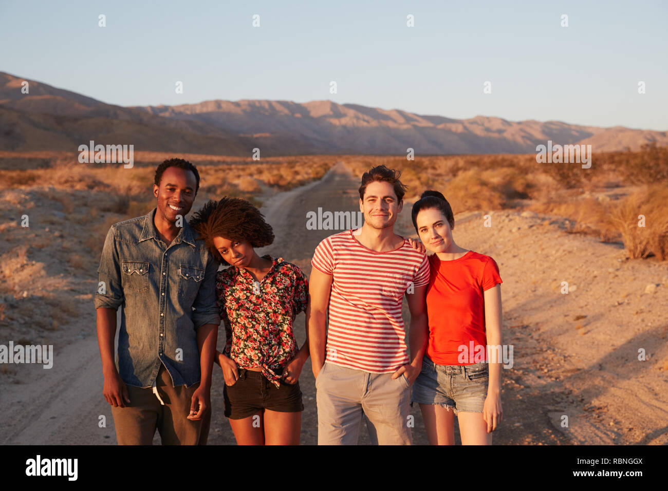 Junge erwachsene Paare in der Wüste lächelnd in die Kamera, in der Nähe Stockfoto