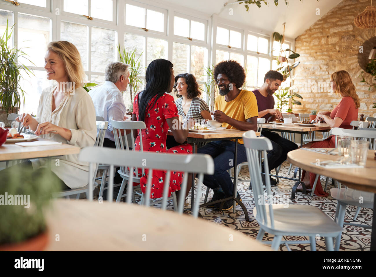 Kunden essen in einem belebten Restaurant in der Tageszeit Stockfoto