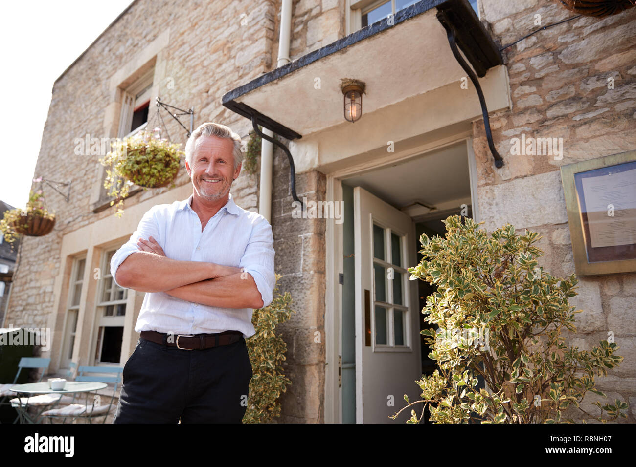 Ältere männliche Restaurant pub Besitzer steht vor dem Eingang Stockfoto