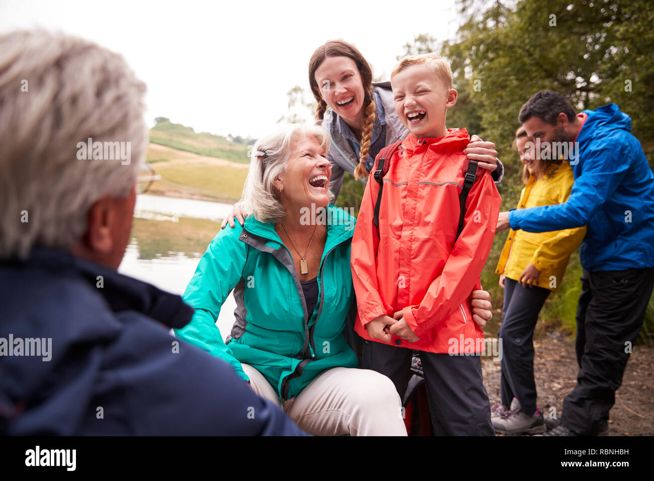 Multi-generation Familie spanding Zeit zusammen am Ufer eines Sees, Lake District, Großbritannien Stockfoto