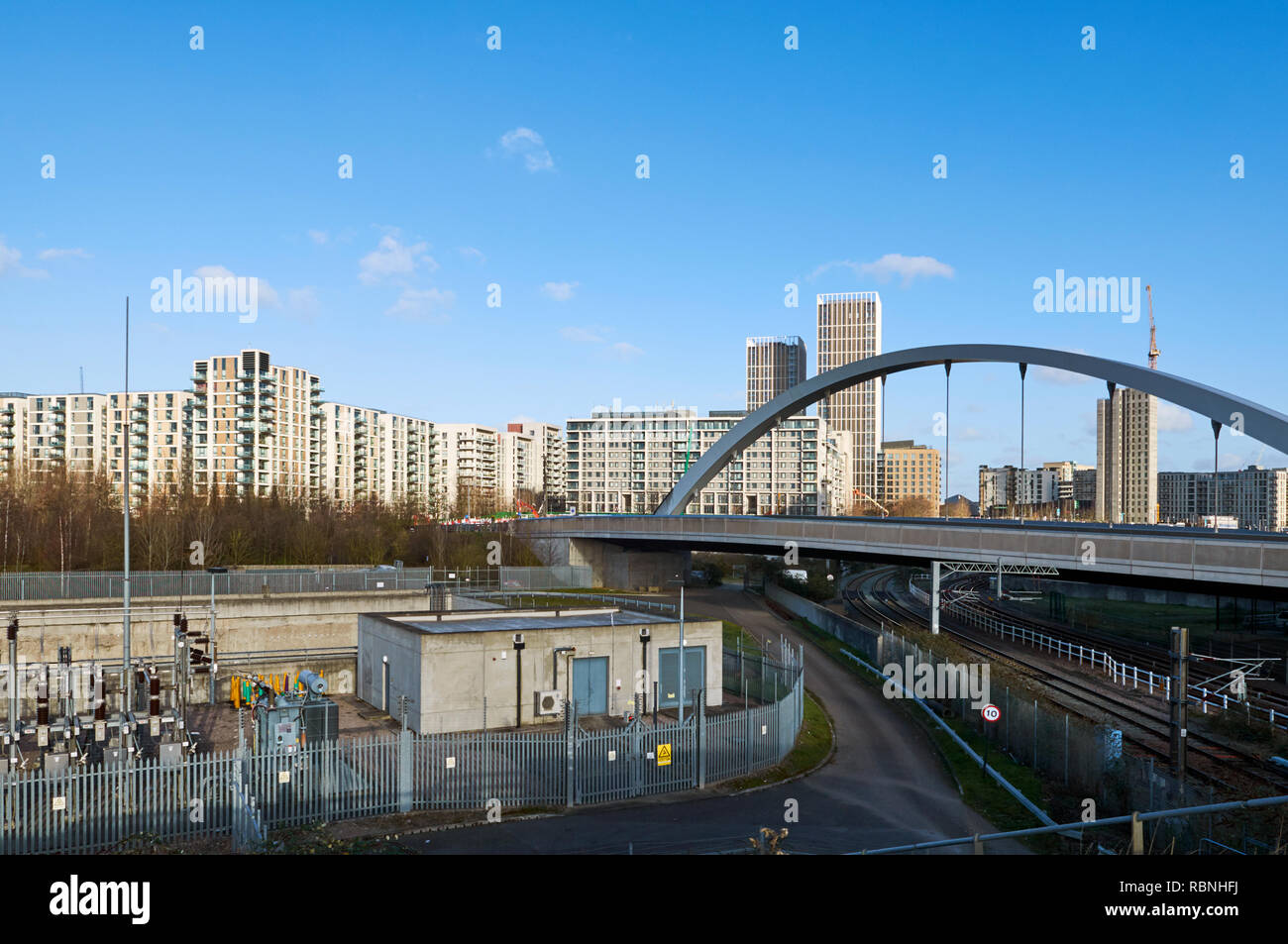 Apartments und Brücke im East Village, Stratford, London UK, von der Queen Elizabeth Olympic Park gesehen Stockfoto
