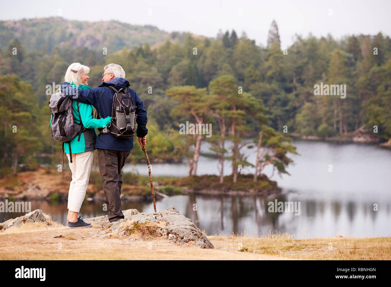 Senior Paar umarmen und bewundernden Blick auf Seen bei einander, Rückansicht suchen Stockfoto