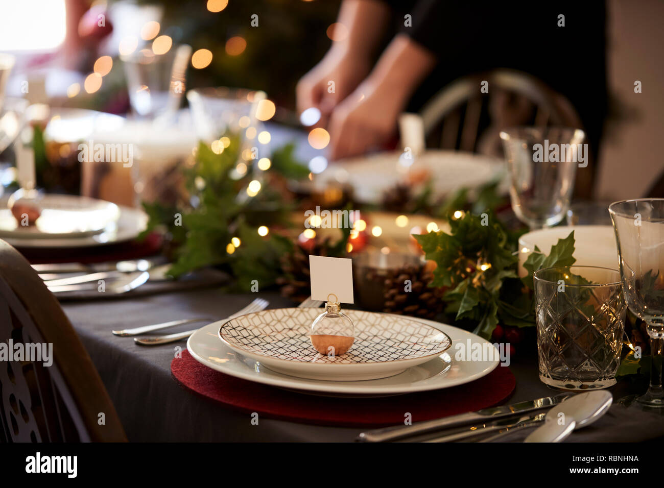 Weihnachten Tischdekoration mit weihnachtskugel Name Kartenhalter auf einer Platte und Grün und Rot Tischdekoration angeordnet Stockfoto