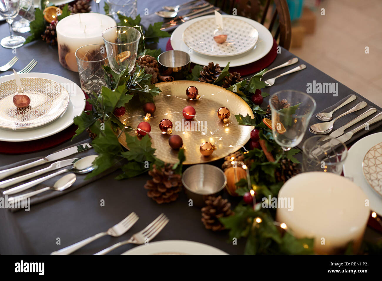 Weihnachten Tischdekoration mit weihnachtskugel name Card Inhaber arrangiert auf Platten, goldene Platte Mittelstück mit Kugeln, und Grüne und rote Tischdekorationen, Erhöhte Ansicht Stockfoto