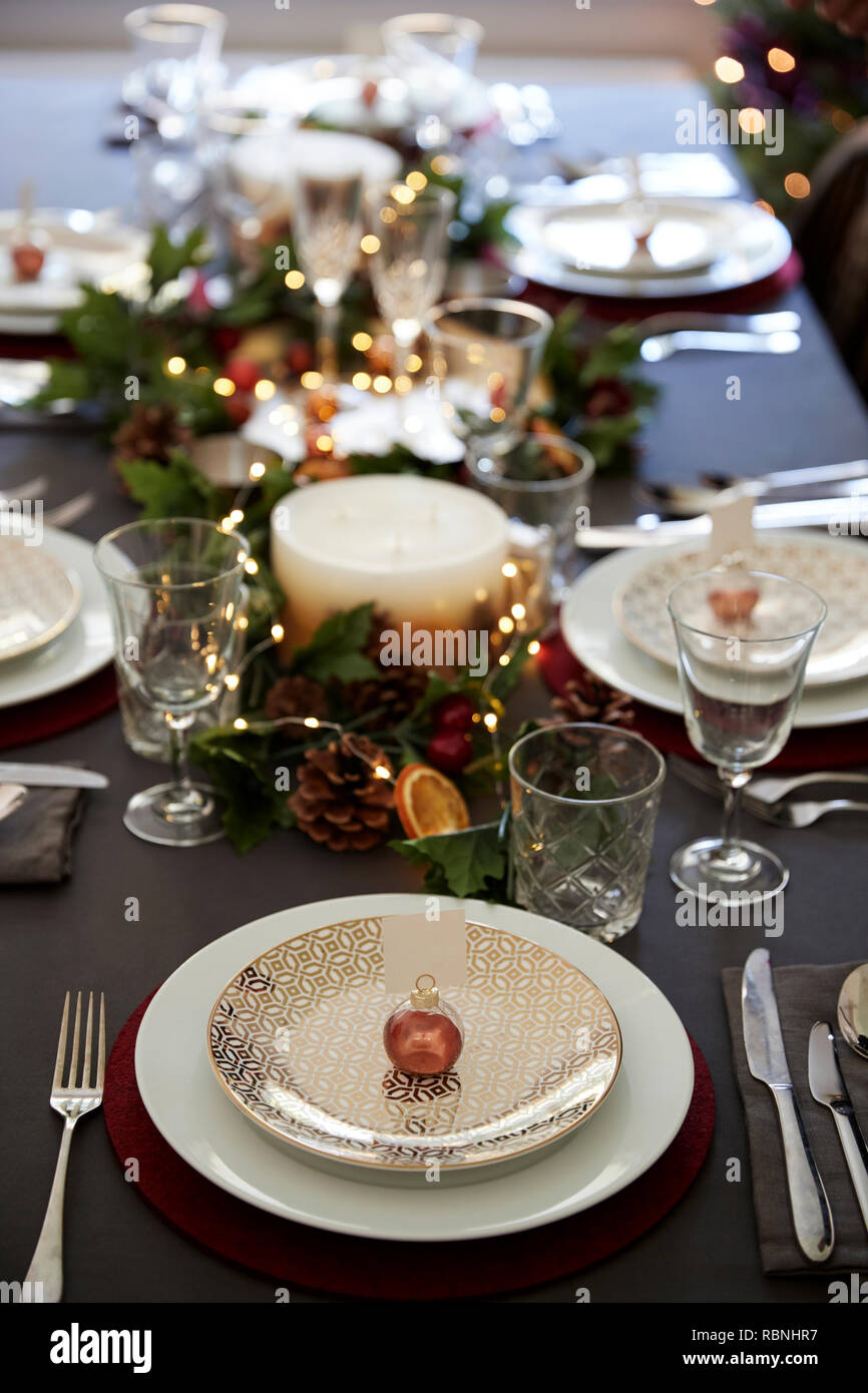 Weihnachten Tischdekoration mit weihnachtskugel Name Kartenhalter auf einer Platte und grün und rot Dekorationen angeordnet, Erhöhte Ansicht Stockfoto