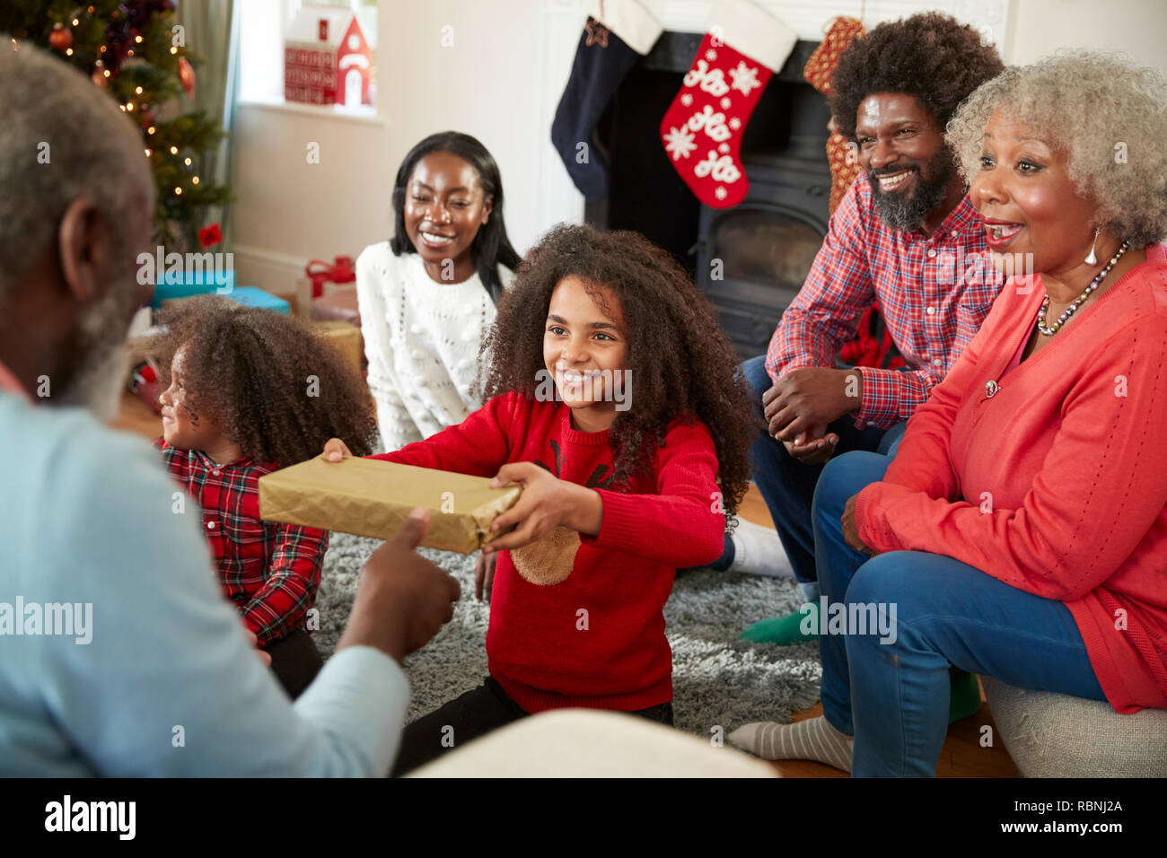 Enkelin, Großvater Geschenk als Multi-Generation Familie Weihnachten feiern zu Hause Stockfoto