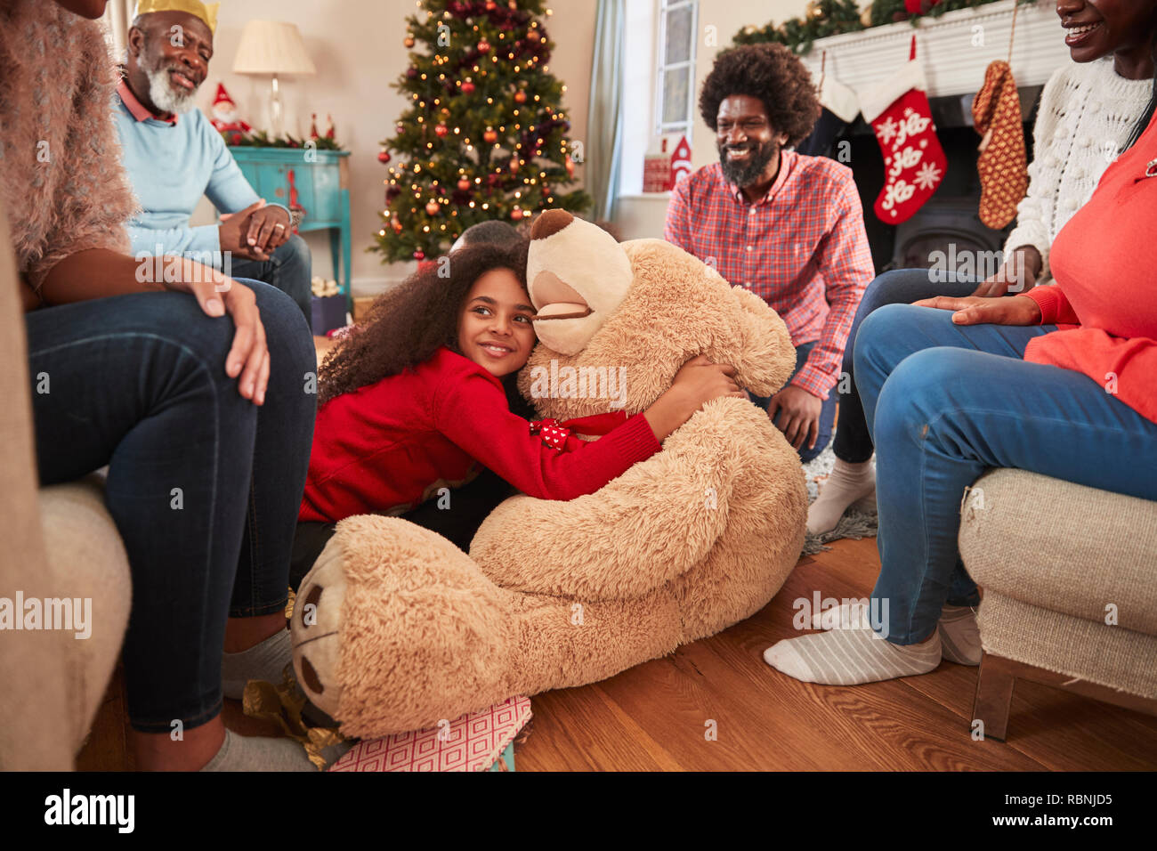 Kinder spielen mit riesigen Teddybär als Multi-Generation Familie Geschenke an Weihnachten Stockfoto