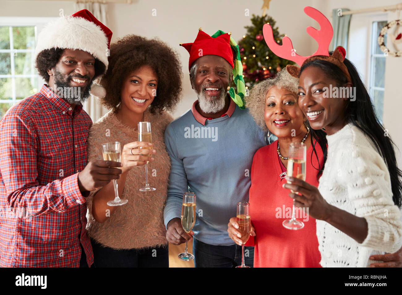 Portrait von Eltern mit erwachsenen Nachkommen einen Toast mit Sekt, wie Sie Weihnachten feiern Stockfoto