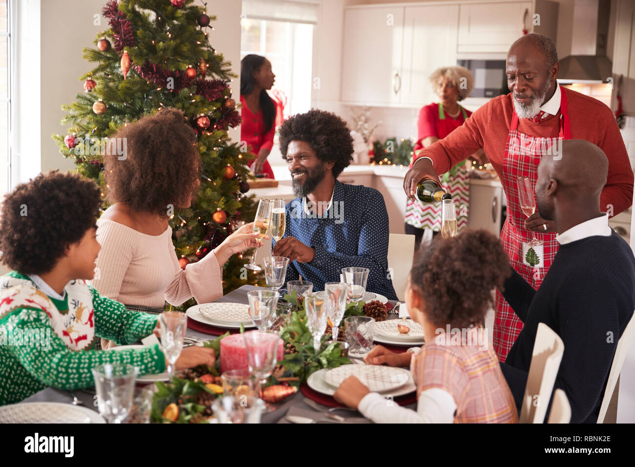Familie sprechen und die Gläser auf den Tisch während einer Generation, gemischten Rennen Familie Weihnachtsfeier Stockfoto