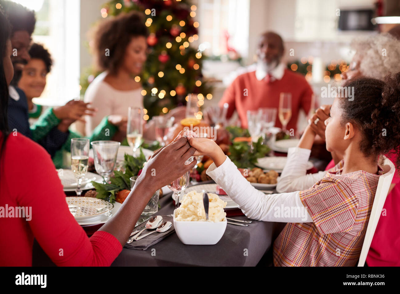 Multi-Generation gemischten Rennen Familie an Weihnachten Tisch halten sich an den Händen sitzen und sagen Gnade, selektiver Fokus, Nahaufnahme Stockfoto