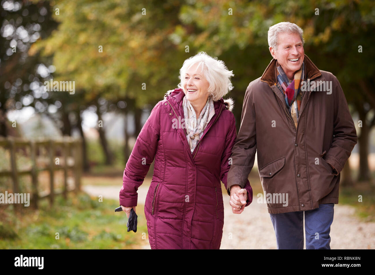 Active Senior Paar auf Herbst zu Fuß auf den Weg durch die Landschaft Stockfoto