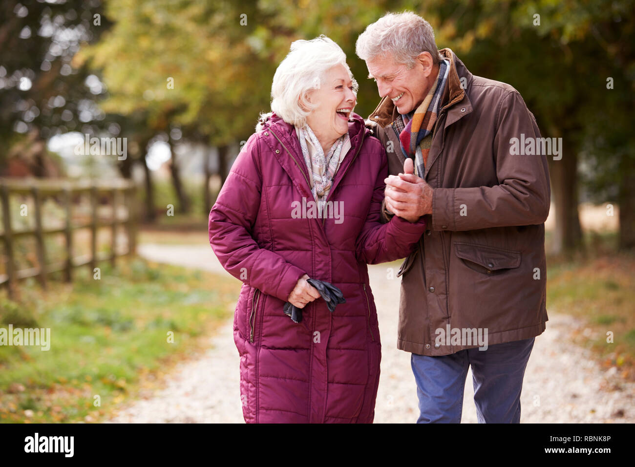 Active Senior Paar auf Herbst zu Fuß auf den Weg durch die Landschaft Stockfoto