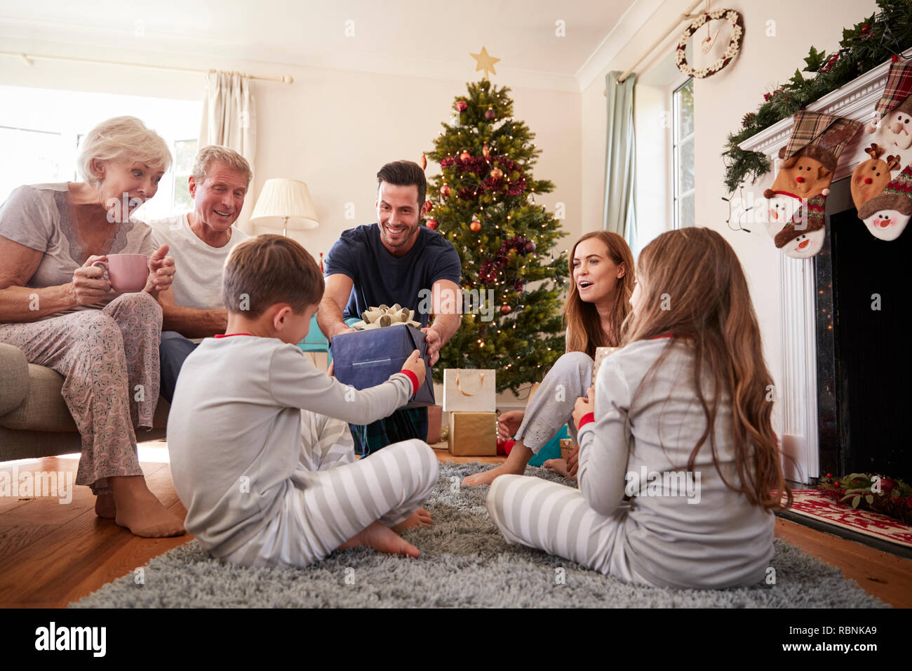 Drei Generation Familie tragen Schlafanzug in der Lounge zu Hause öffnen Geschenke an Weihnachten Stockfoto