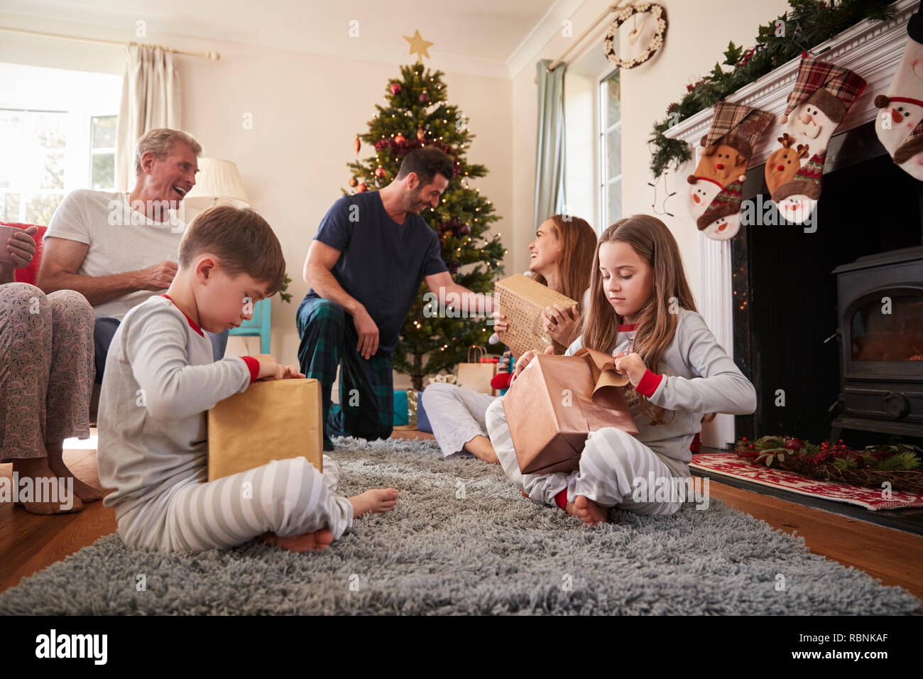 Drei Generation Familie tragen Schlafanzug in der Lounge zu Hause öffnen Geschenke an Weihnachten Stockfoto