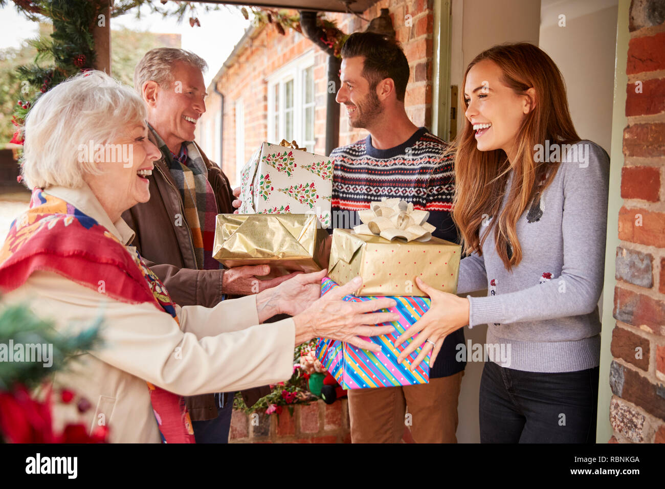 Die großeltern von Familie begrüßt, wie Sie ankommen zu besuchen und an Weihnachten mit Geschenken Stockfoto