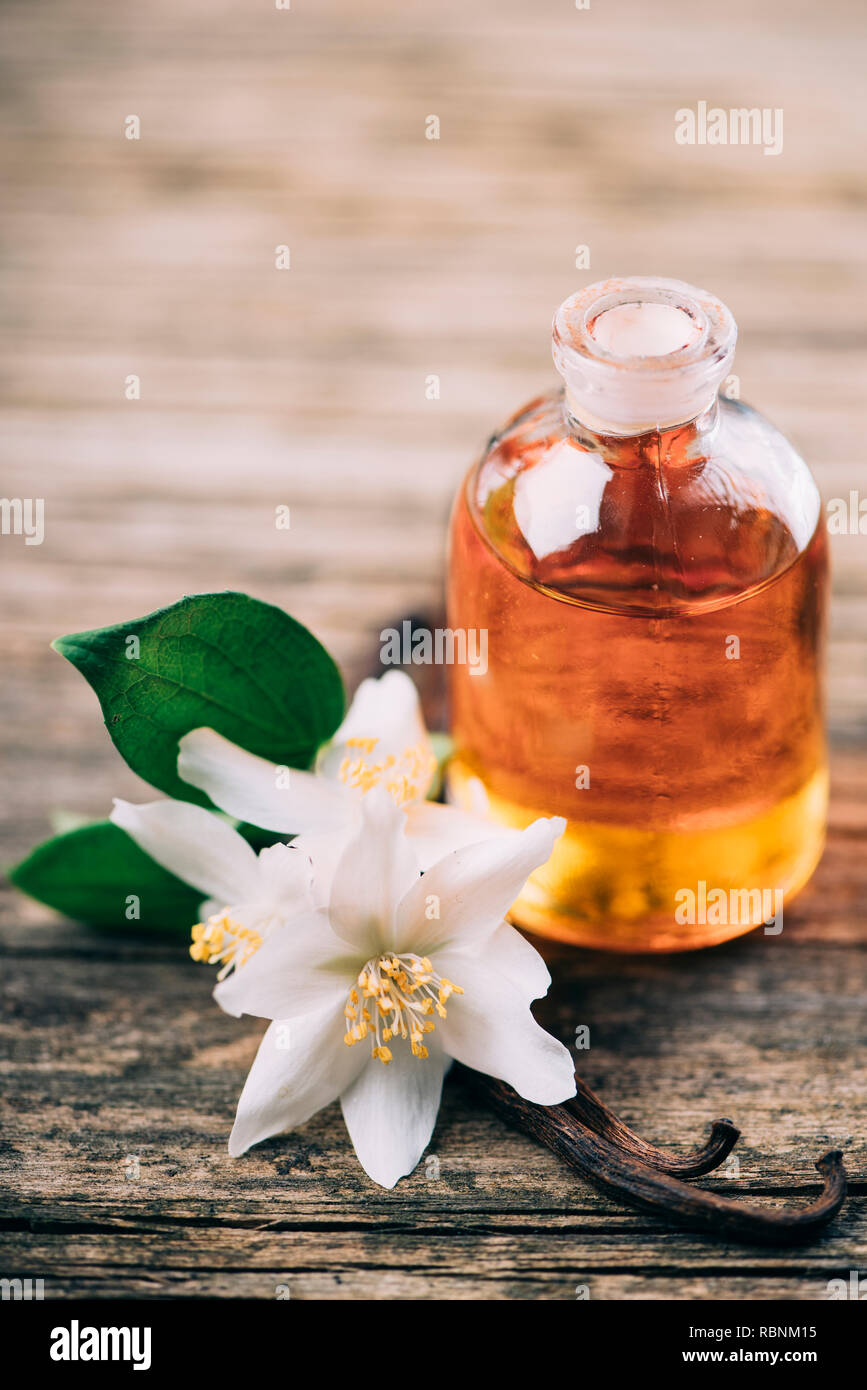 Ätherisches Öl mit Jasmin Blume und Vanille. Aromatherapie Massage Öl auf rustikalen Holzmöbeln Hintergrund. Stockfoto