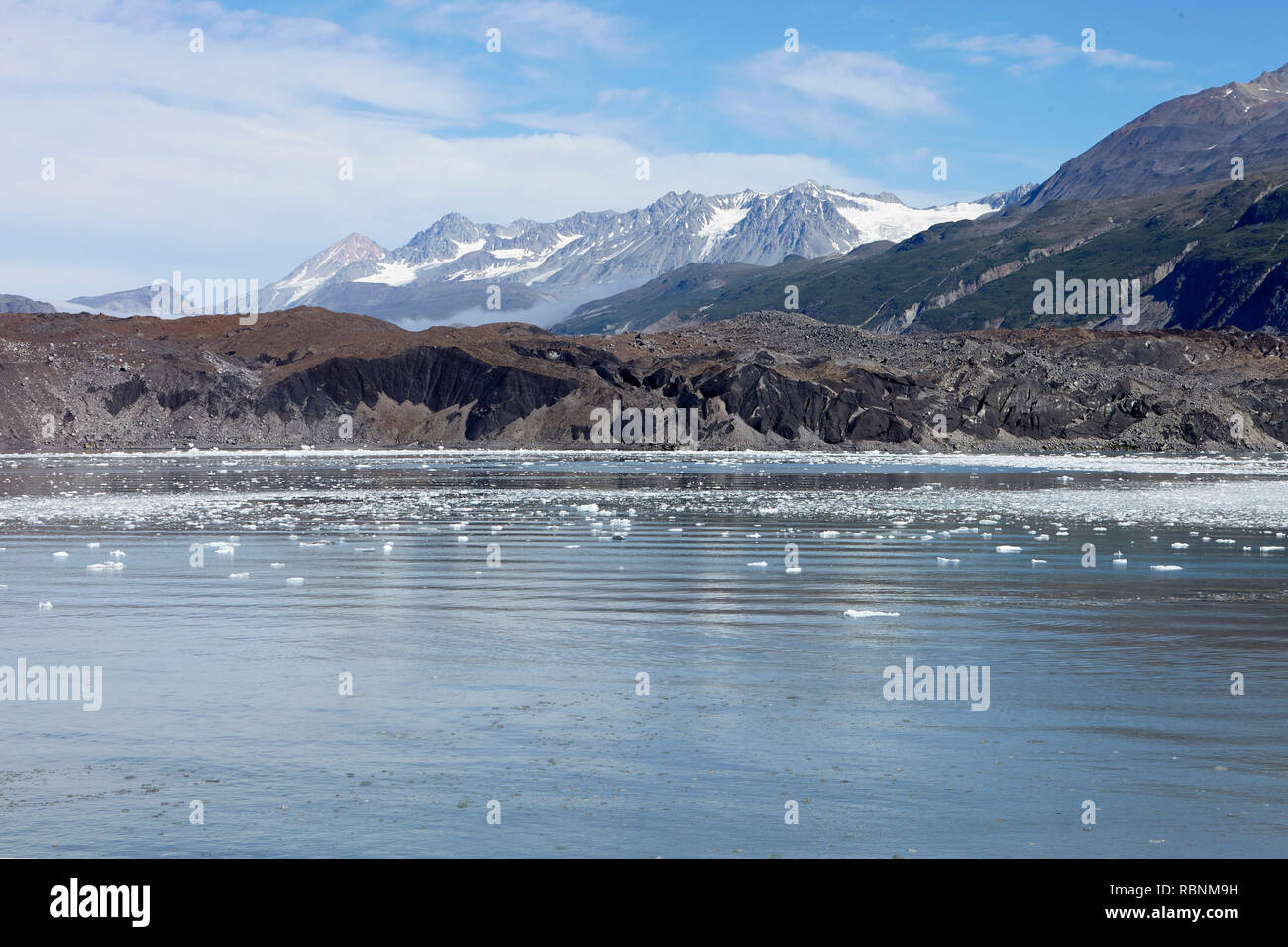 Eis schwimmt auf der Oberfläche mit Bergen im Hintergrund in Alaska Stockfoto