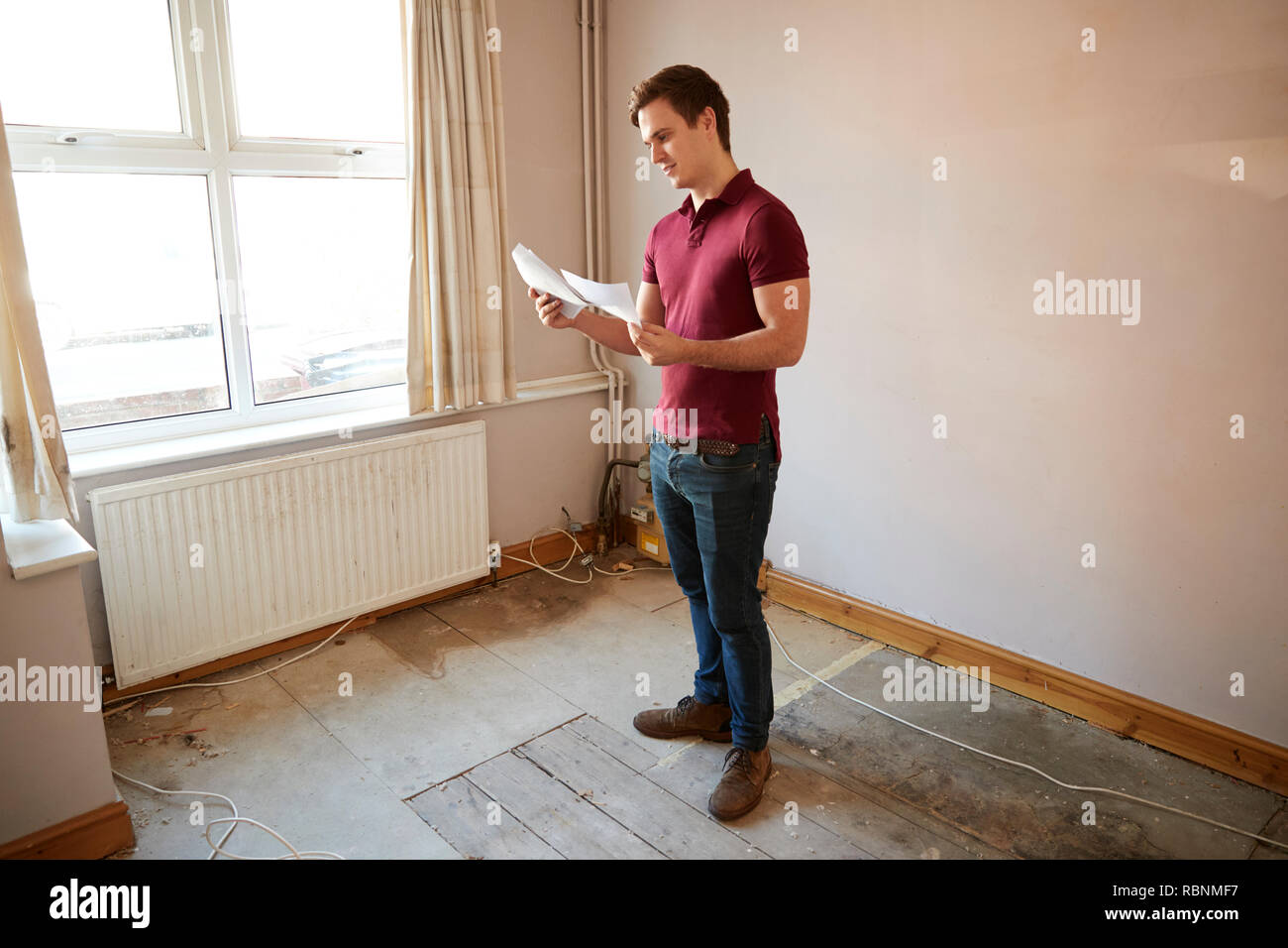 Männliche Erstkäufer bei Haus Umfrage im Zimmer renoviert werden Stockfoto