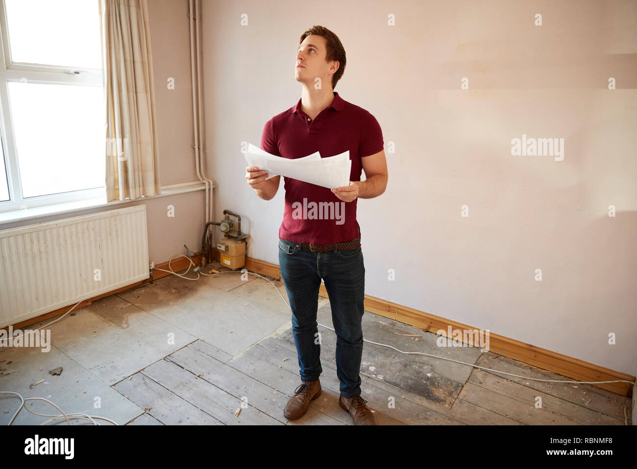 Männliche Erstkäufer bei Haus Umfrage im Zimmer renoviert werden Stockfoto