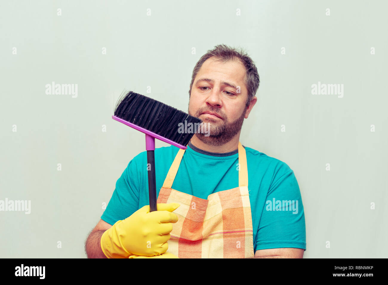 Emotionale bärtiger Mann mit einem Besen. Hellen Hintergrund. Stockfoto