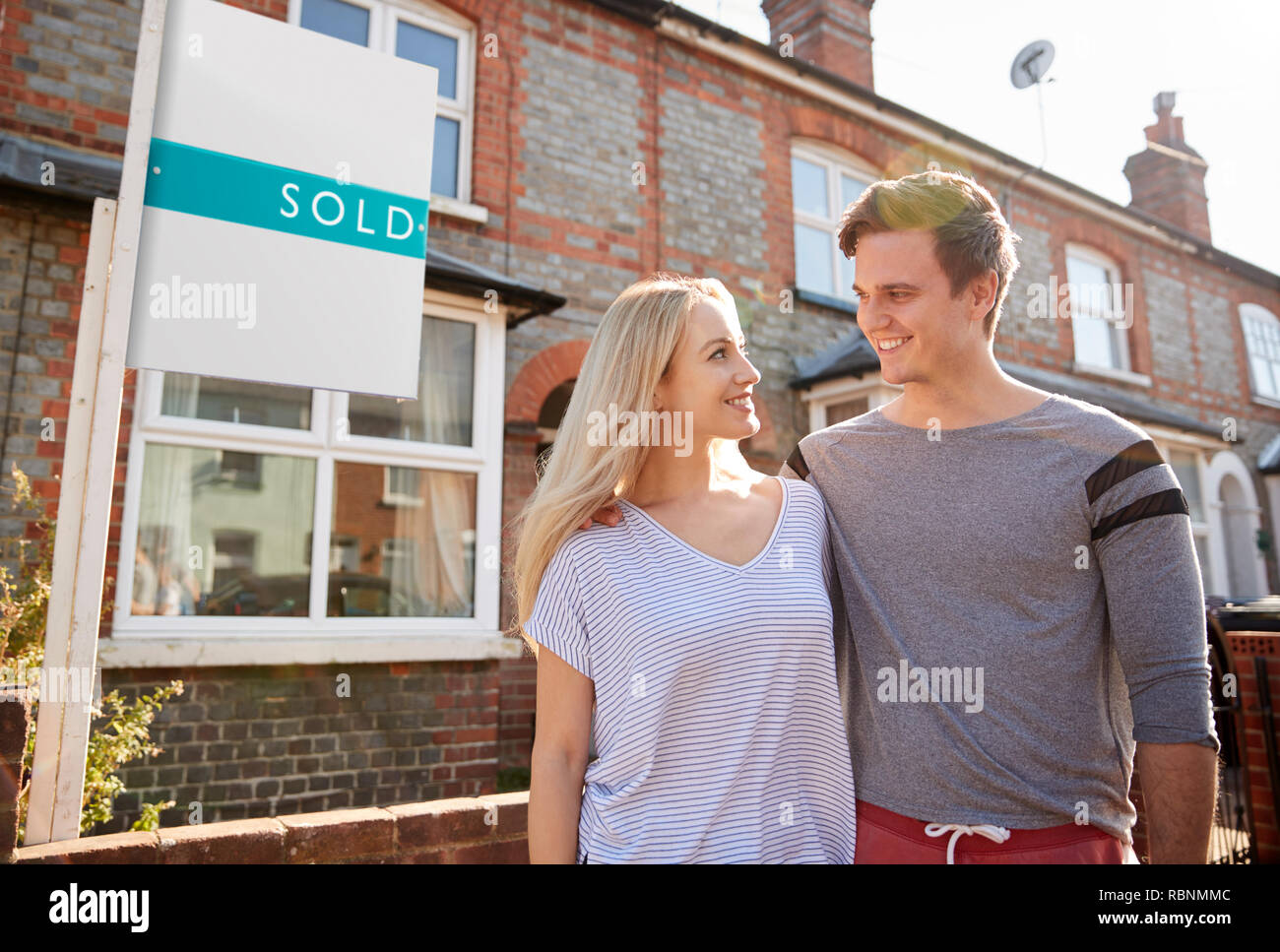 Paar außerhalb neues Zuhause Mit verkauften Zeichen aufgeregt Stockfoto