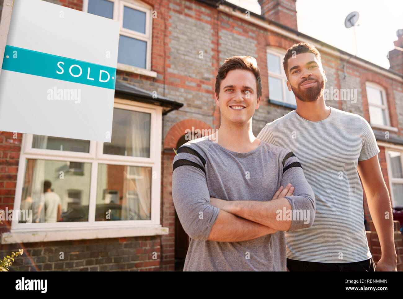 Porträt von zwei Männern außerhalb neues Zuhause Mit verkauften Zeichen Stockfoto