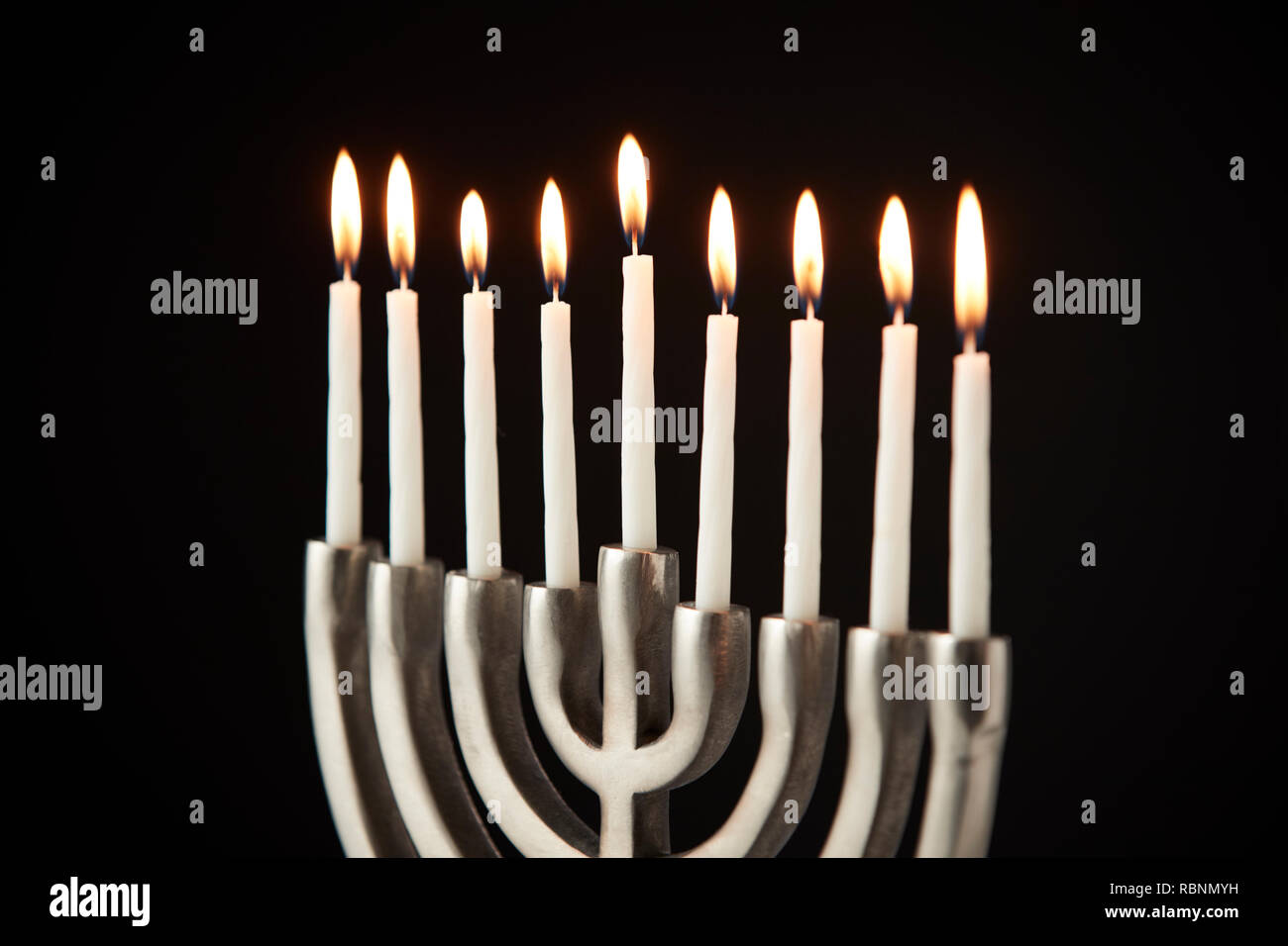 Kerzen auf Metall Hanukkah Menorah gegen Schwarze Studio Hintergrund Stockfoto
