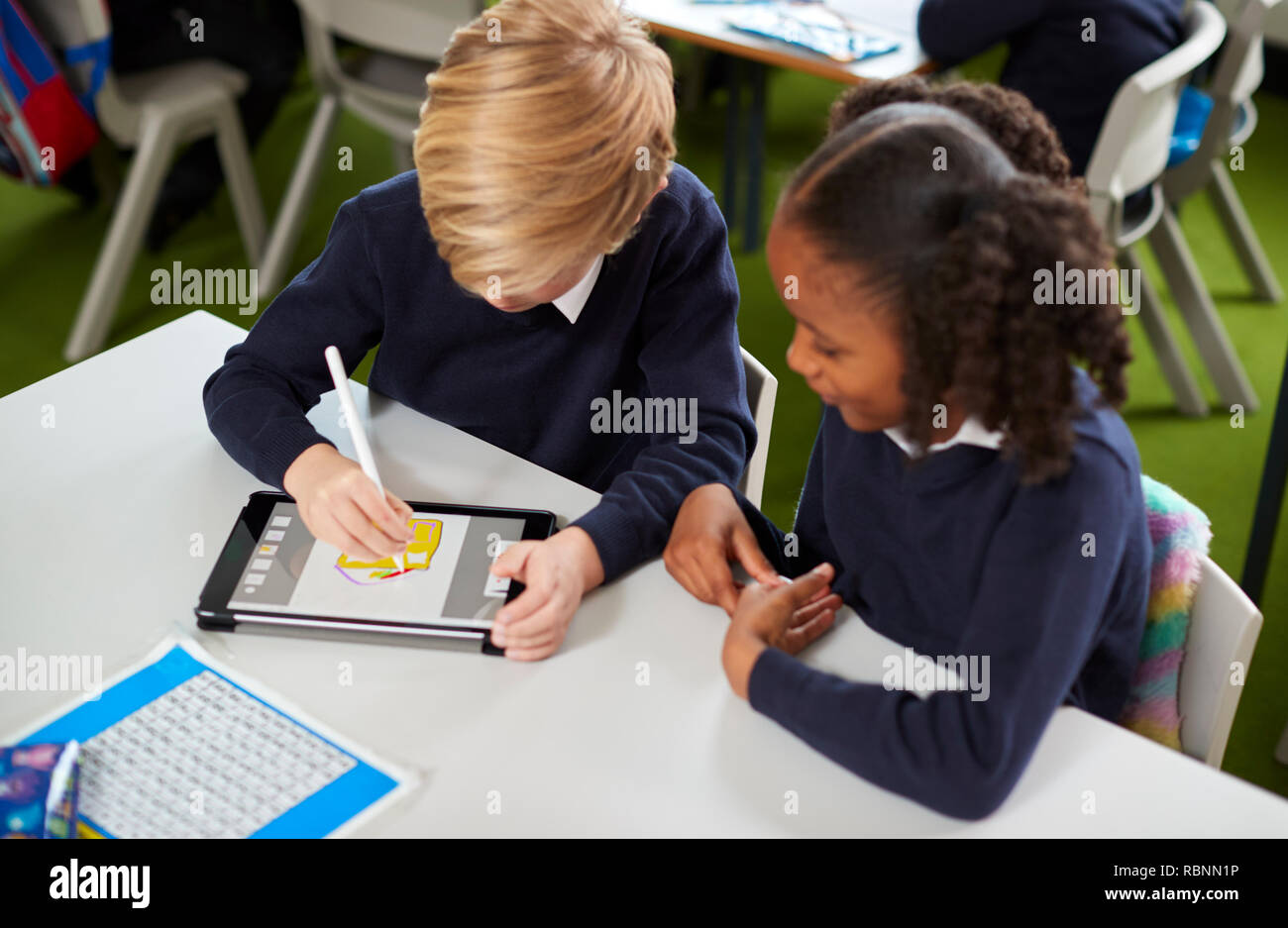 Ansicht von einem Mädchen und einem mit einem Tablet Computer und Stylus zusammen in eine Grundschule klasse Junge Stockfoto