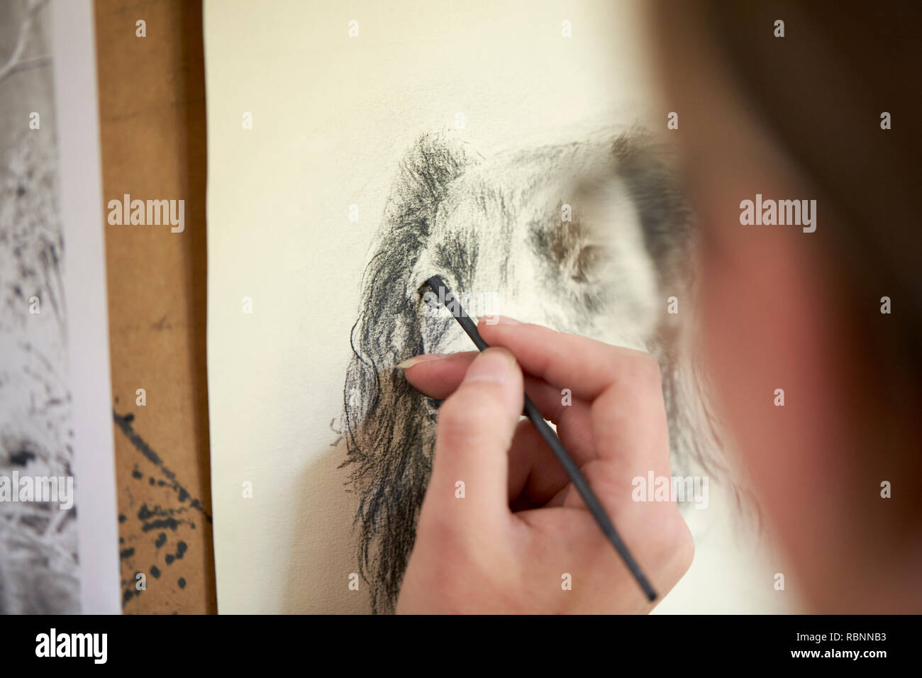 Nahaufnahme von Artist Sitzen an Staffelei Zeichnung Bild des Hundes in der Holzkohle Stockfoto