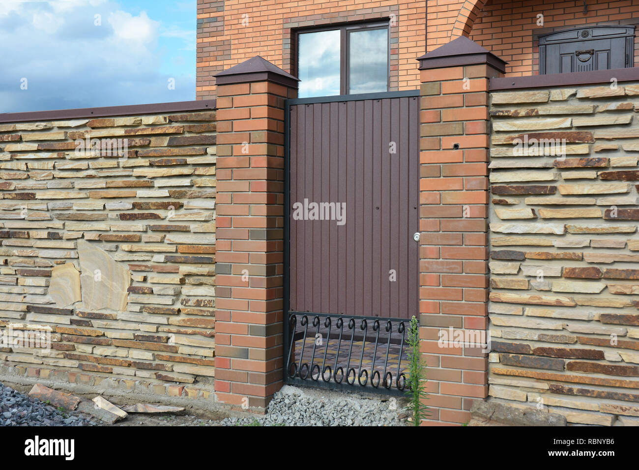 Installation von Stone Fence mit Metall Tür Stockfoto