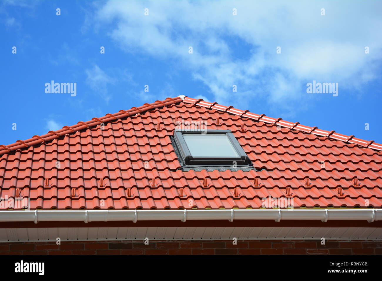 Oberlicht auf rot Keramik fliesen Haus Dach mit Regenrinne. Oberlichter, Dach Windows und Sun Tunneln. Dachgeschoss Dachfenster Lösung outdoor. Stockfoto