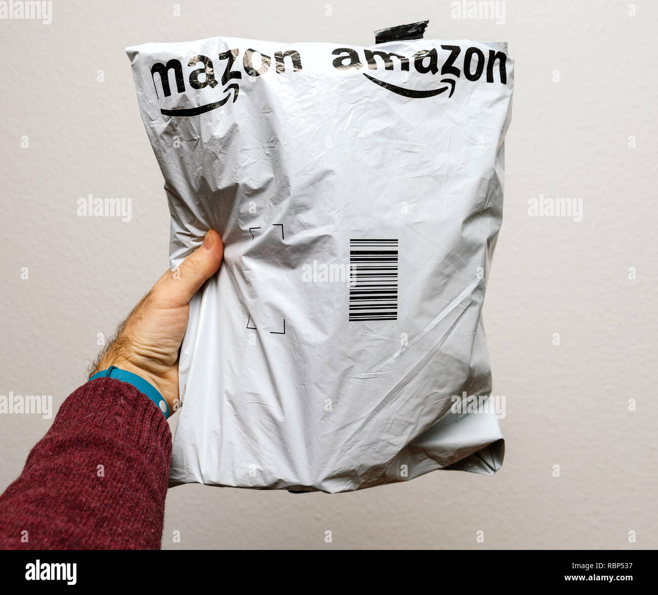 PARIS, Frankreich, 23.JANUAR 2018: Mann, gegen den weißen Hintergrund eine  Kunststoff paket Lieferung von Amazon Paket, Kleider oder Schuhe  Stockfotografie - Alamy