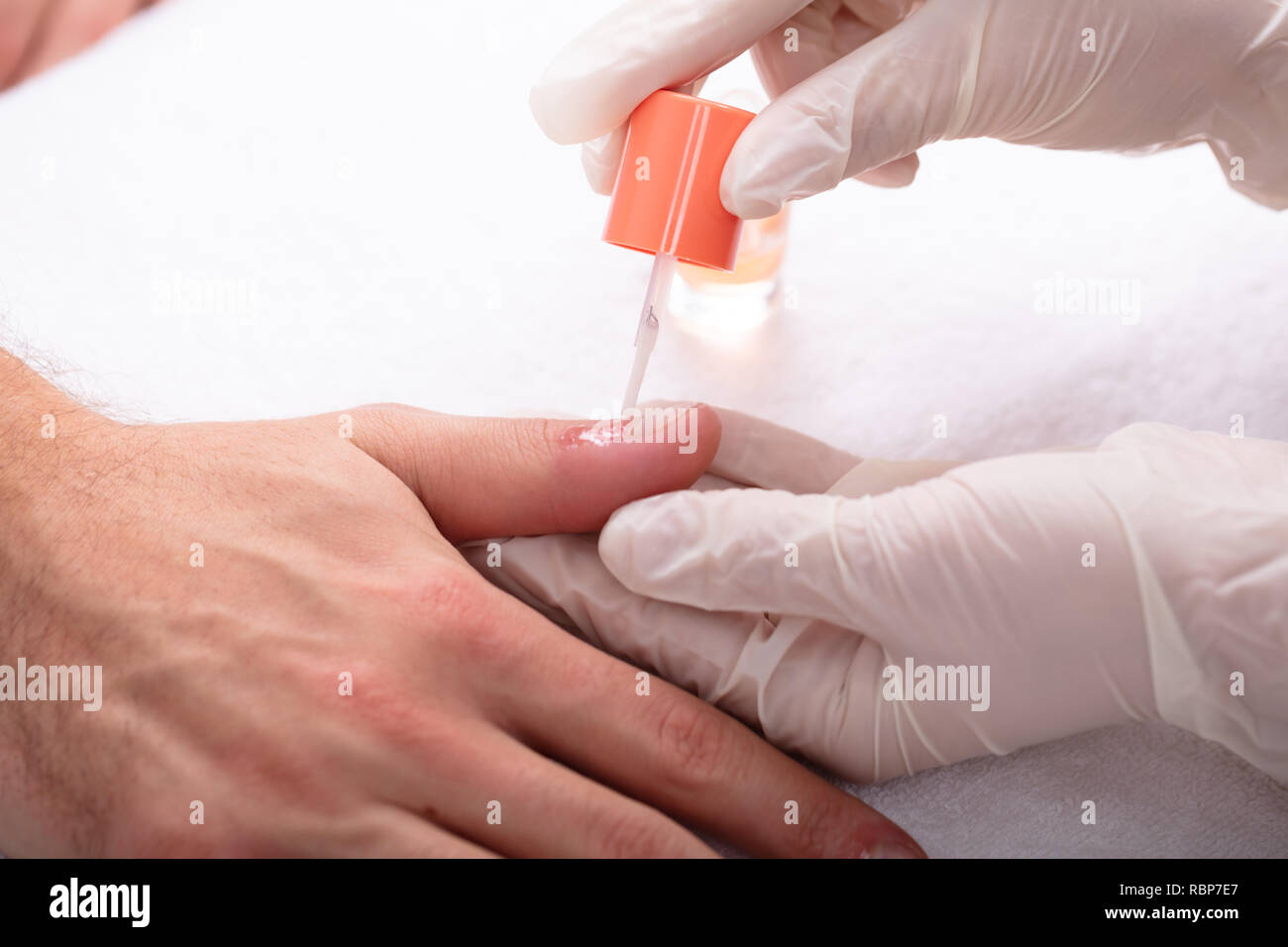 Close-up Kosmetikerin Anwendung Nagel Öl auf der Hand in Spa Stockfoto