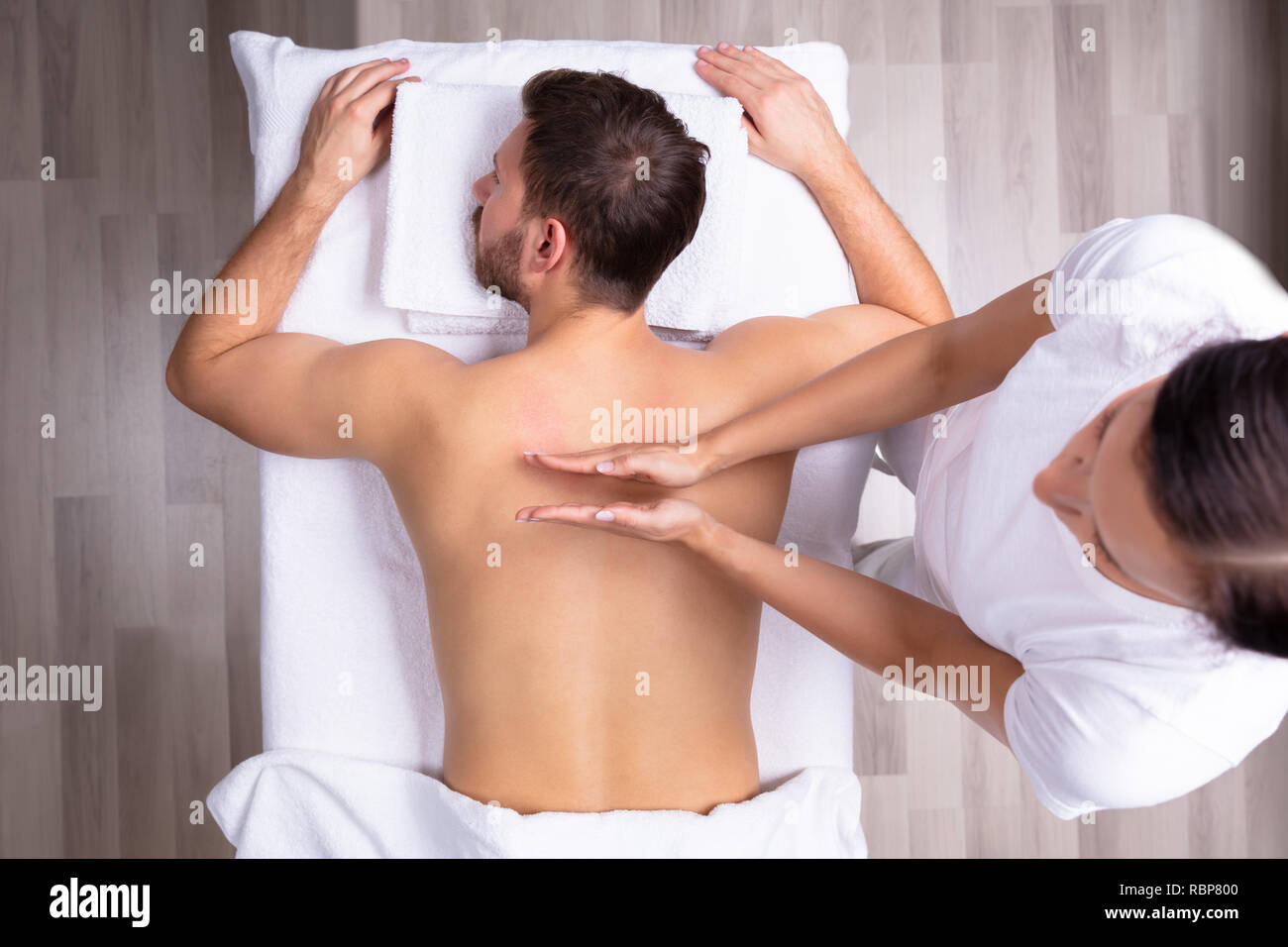 Nahaufnahme einer entspannten jungen Mann empfangen Schulter Massage Stockfoto