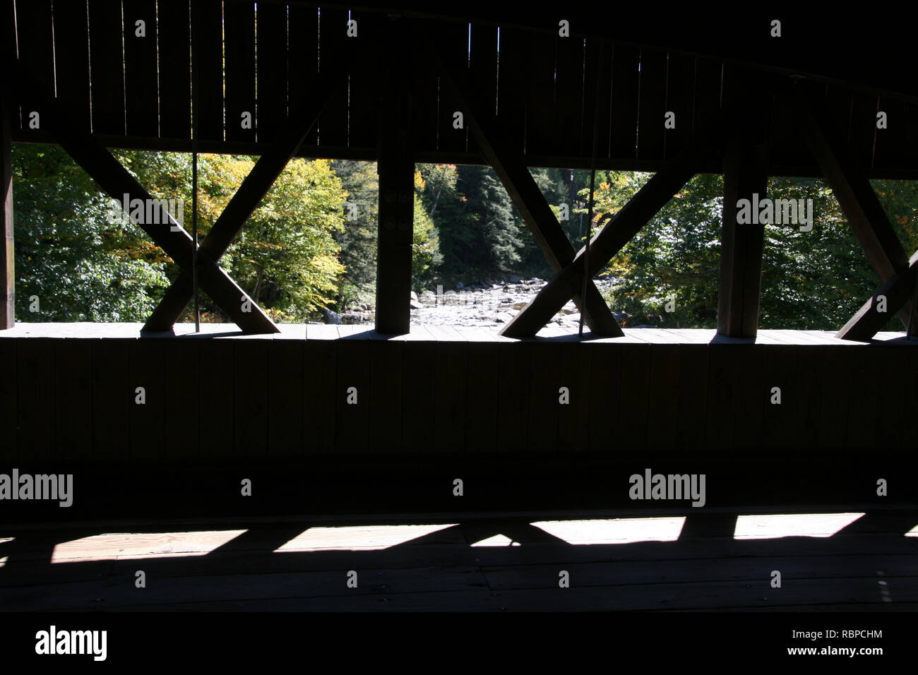 Honeymoon Covered Bridge, Jackson, New Hampshire. Spanning Ellis River. Sunlit detail Übersicht Schatten, Holz- bau und Ellis River hinaus. Stockfoto