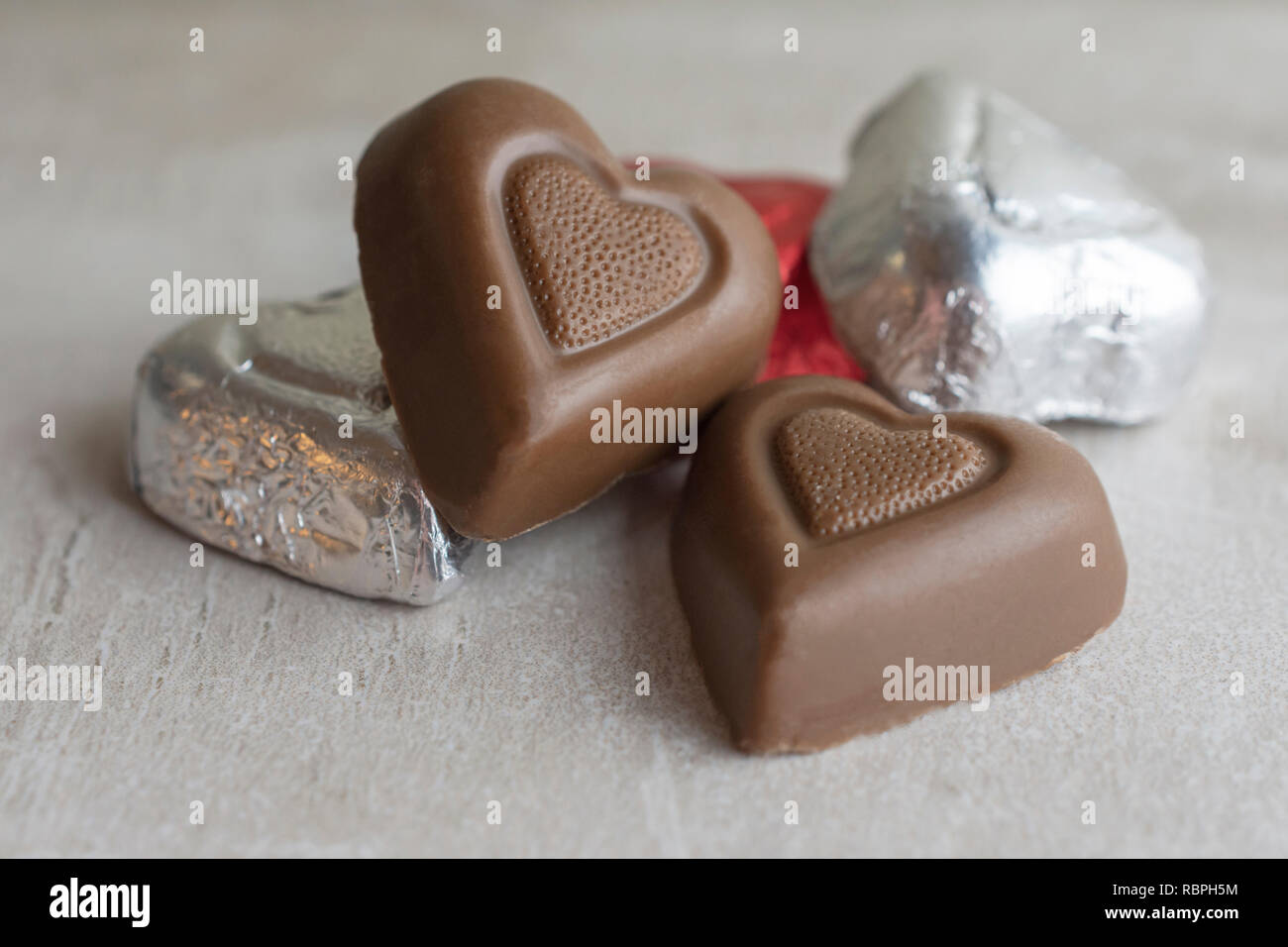 Gruppe von Herz Schokolade auf tan Fliese. Nähe zu sehen. Stockfoto