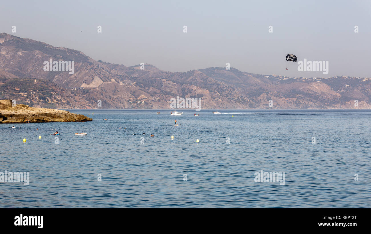 Verschiedene Wassersport am Strand. Landschaft der mediterranen Küste im Sommer, voll von Touristen. Urlaub am Meer an der Costa del Sol Stockfoto