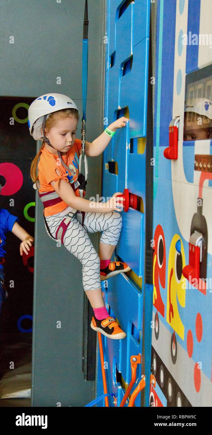 5 Jahre altes Mädchen in Helm klettern eine Felswand indoor Stockfoto