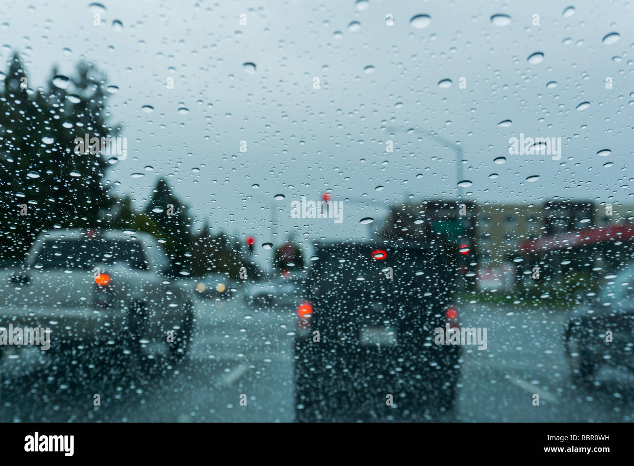 Regentropfen auf der Windschutzscheibe während der Fahrt an einem regnerischen Tag; Kalifornien Stockfoto