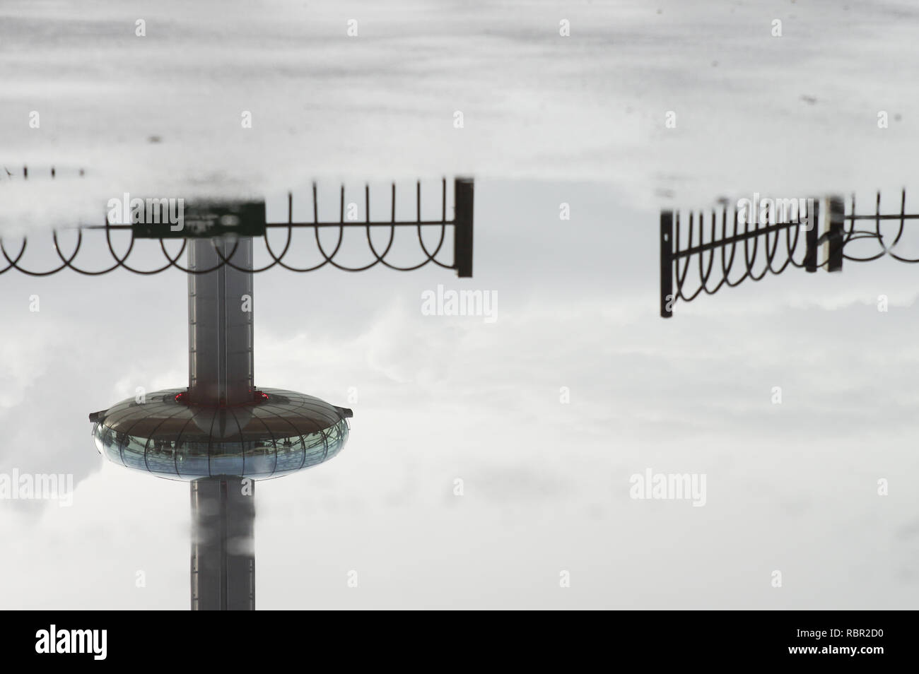 Reflexion der Brighton (UK) British Airways ich 360 Turm in einer Pfütze auf dem Bürgersteig Stockfoto