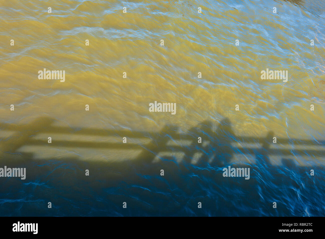 Minimalistisches Bild der Schatten im Wasser unter einem Pier am Columbia River Gorge widerspiegelt Stockfoto